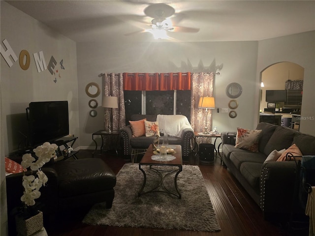 living room with dark hardwood / wood-style flooring and ceiling fan