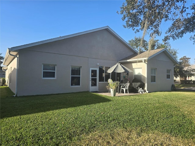 back of property featuring a yard and a patio