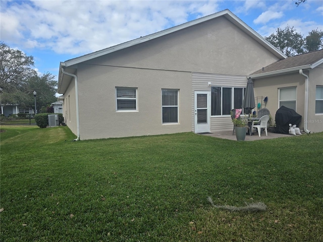 rear view of property with a yard, a patio, and central air condition unit