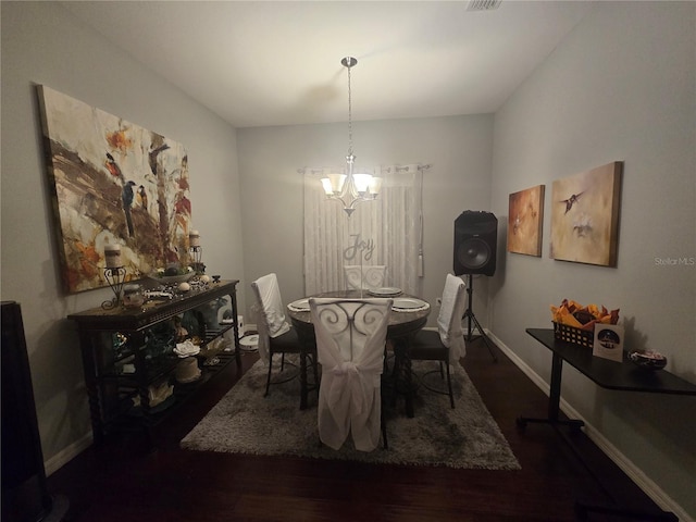 dining room with dark hardwood / wood-style floors and a chandelier