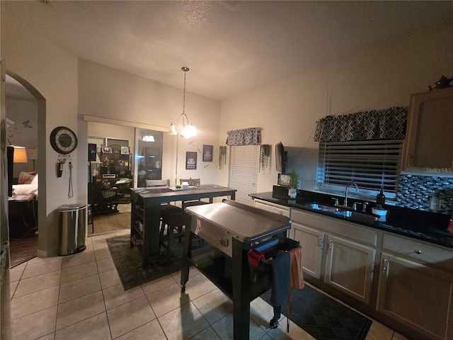 dining space featuring a notable chandelier, light tile patterned floors, and sink