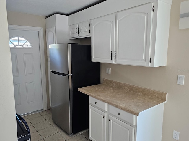 kitchen with white cabinetry, stainless steel fridge, and light tile patterned floors