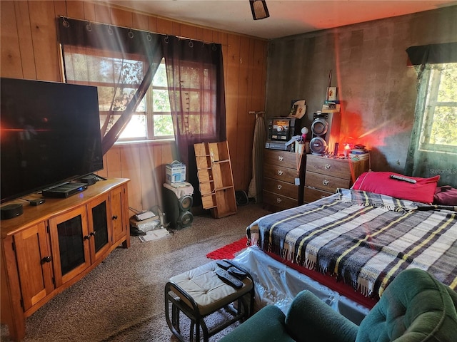 bedroom with carpet, ceiling fan, and wooden walls