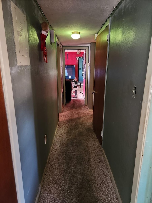 corridor featuring electric panel, dark carpet, and a textured ceiling