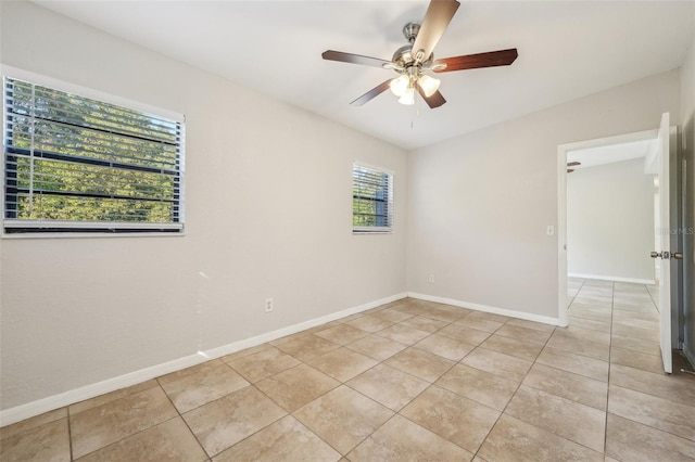 empty room with ceiling fan and light tile patterned flooring