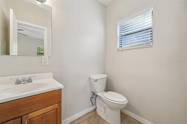 bathroom with toilet, tile patterned flooring, plenty of natural light, and vanity