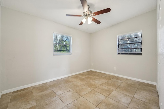 tiled empty room with ceiling fan and plenty of natural light