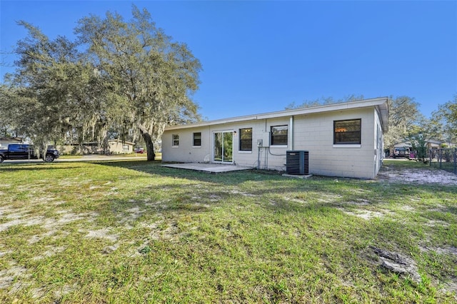 rear view of property featuring central AC unit, a patio area, and a yard