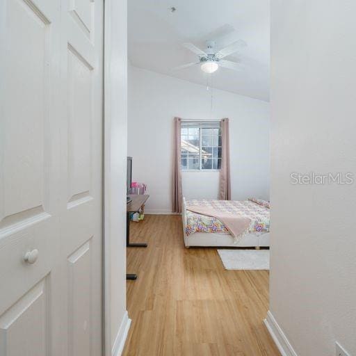 bedroom with lofted ceiling and light wood-type flooring