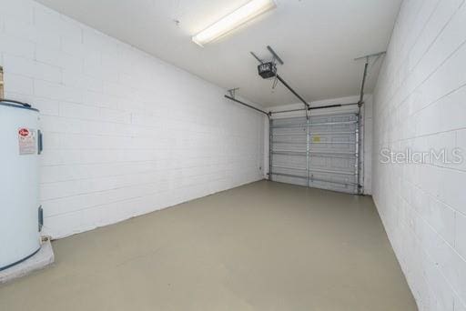 garage with a garage door opener and electric water heater