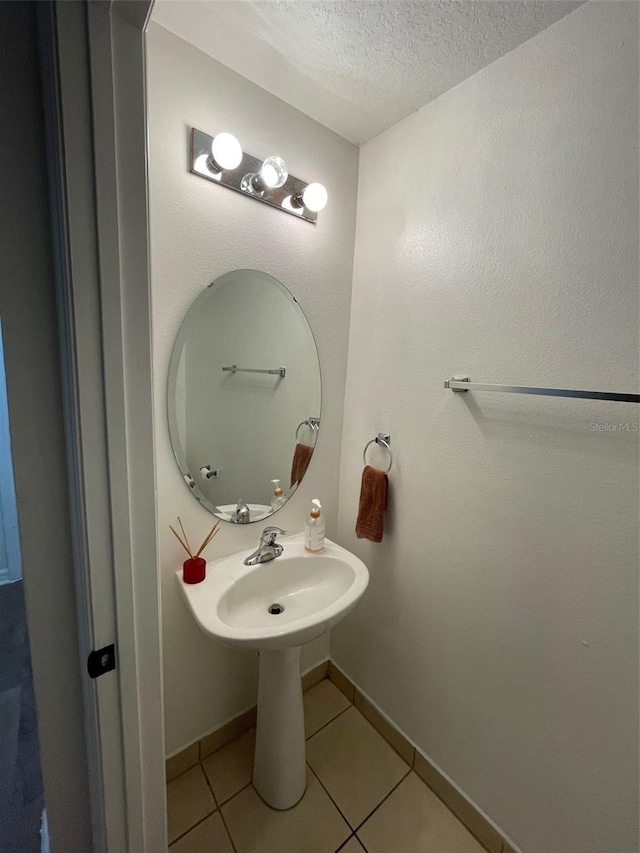 bathroom featuring tile patterned flooring and a textured ceiling