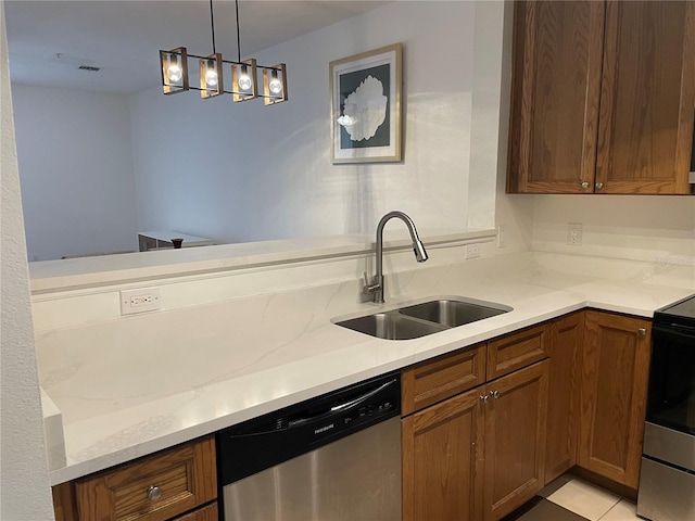 kitchen with stainless steel appliances, decorative light fixtures, light stone countertops, and sink