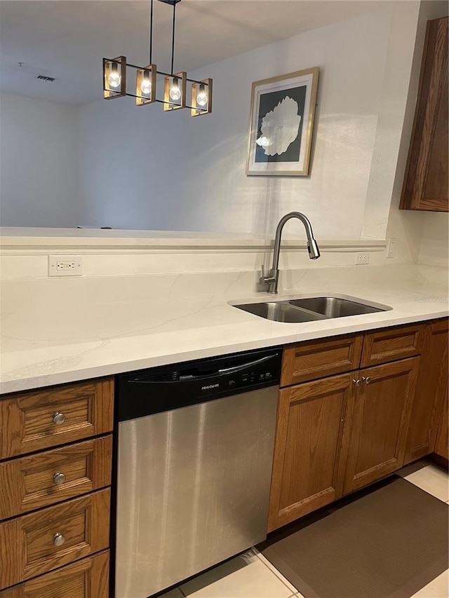 kitchen featuring pendant lighting, sink, light stone counters, and dishwasher