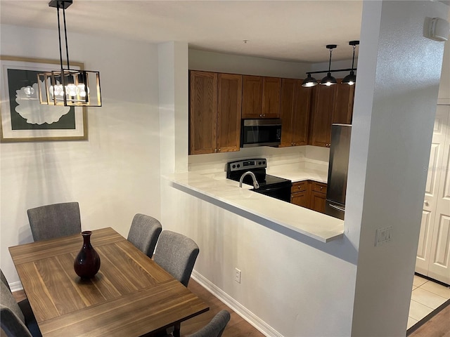 dining room featuring kitchen peninsula and hanging light fixtures