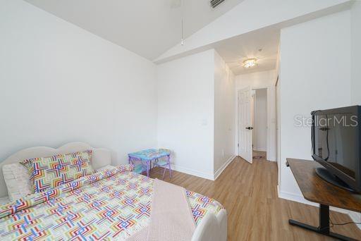 bedroom with hardwood / wood-style flooring and vaulted ceiling