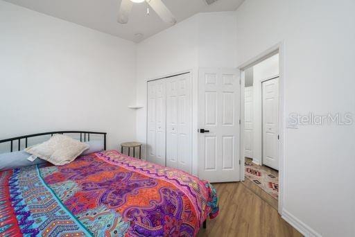 bedroom featuring ceiling fan, a closet, and light hardwood / wood-style flooring