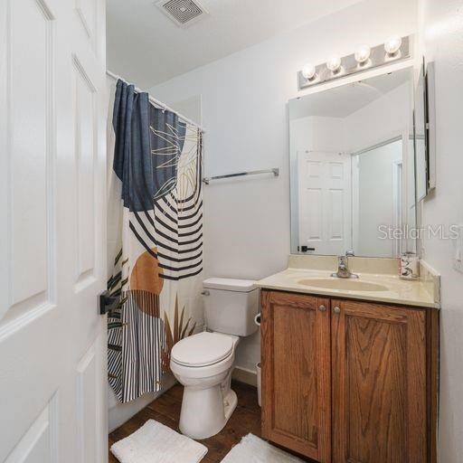 bathroom with vanity, walk in shower, and toilet