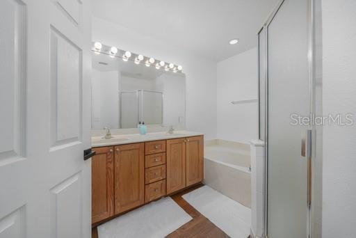 bathroom featuring vanity, hardwood / wood-style floors, and shower with separate bathtub