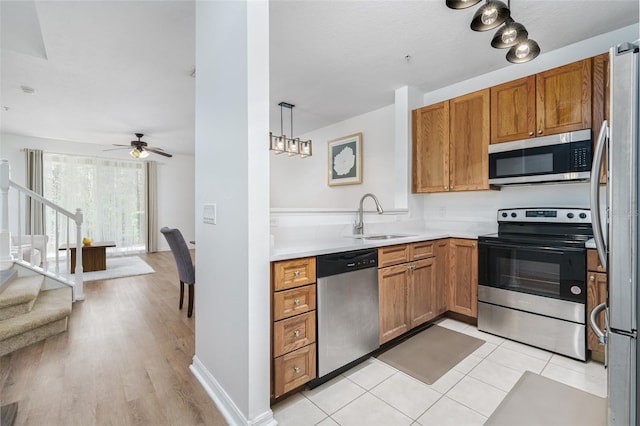 kitchen featuring sink, hanging light fixtures, light tile patterned floors, ceiling fan, and stainless steel appliances