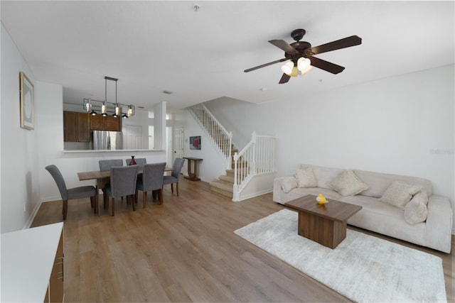 living room with ceiling fan and light hardwood / wood-style flooring