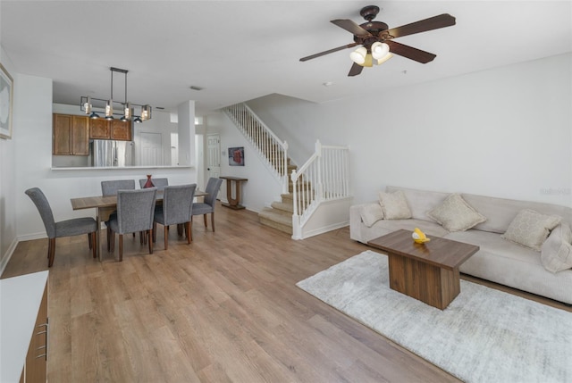 living room featuring ceiling fan and light hardwood / wood-style flooring