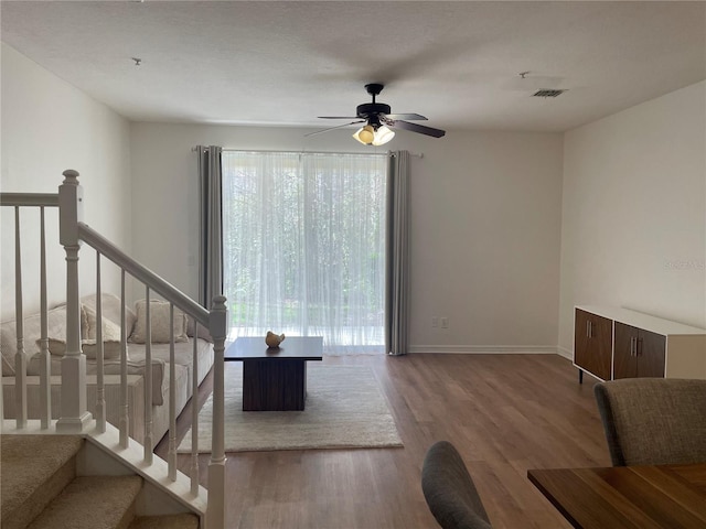 unfurnished living room featuring hardwood / wood-style floors and ceiling fan