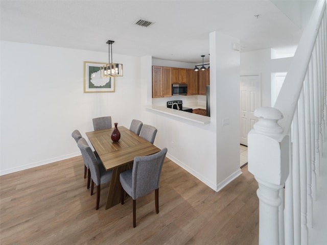 dining area featuring hardwood / wood-style flooring and an inviting chandelier