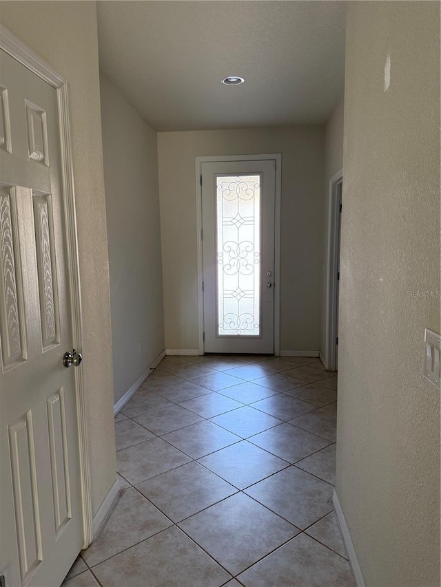 doorway to outside with light tile patterned floors