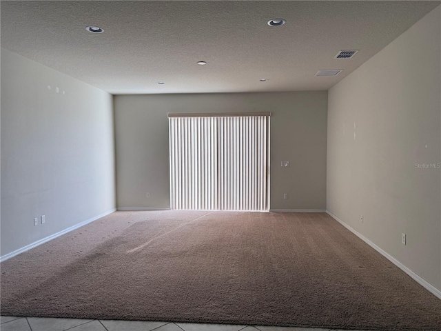 empty room with a textured ceiling and light carpet