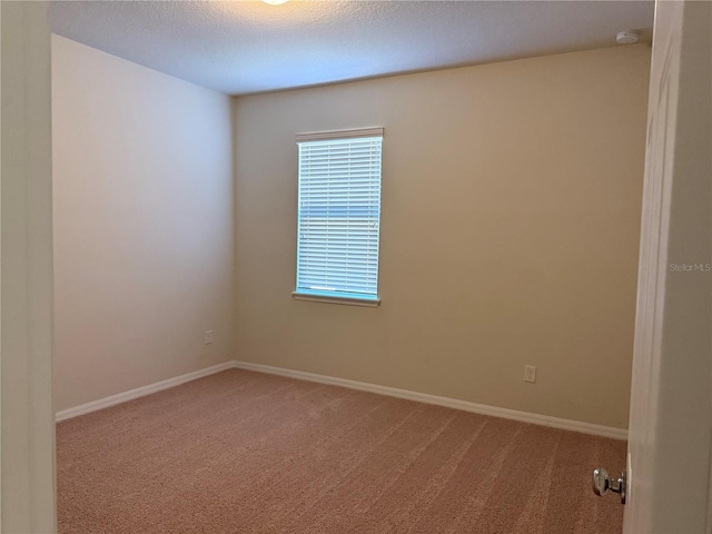 carpeted empty room featuring a textured ceiling