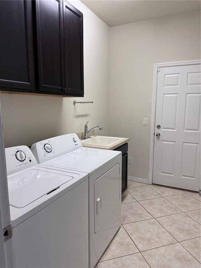 laundry room featuring washer and clothes dryer, light tile patterned flooring, cabinets, and sink