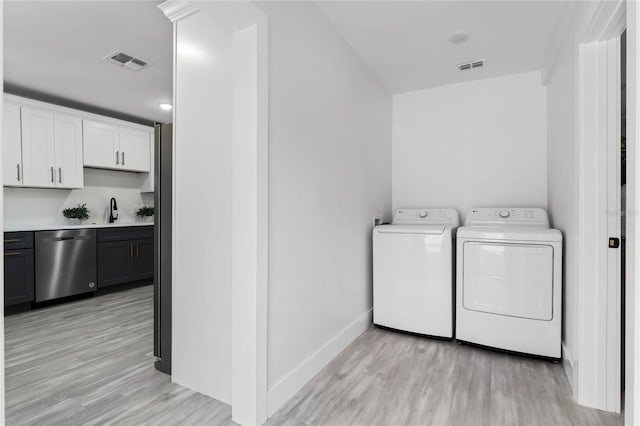 washroom with independent washer and dryer, light hardwood / wood-style floors, and sink