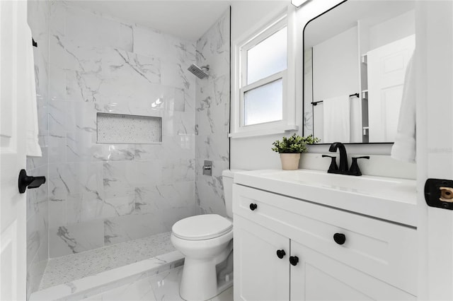 bathroom featuring vanity, toilet, and tiled shower