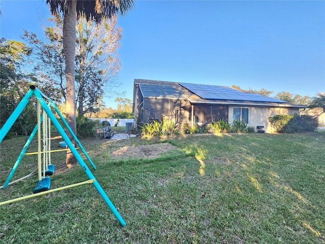 1022 Bartlett Ct, Oviedo, FL 32765 - rear view of property featuring roof mounted solar panels, a sunroom, and a yard