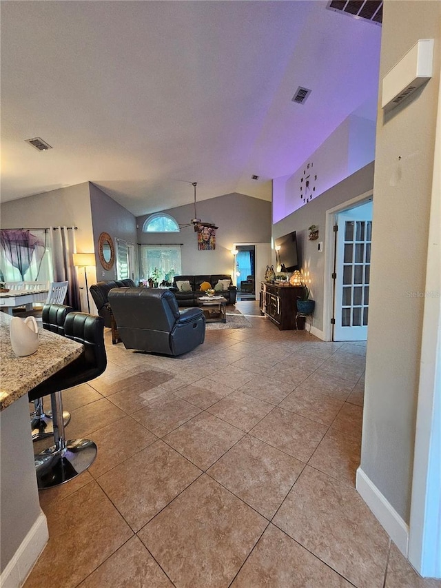 tiled living room featuring vaulted ceiling