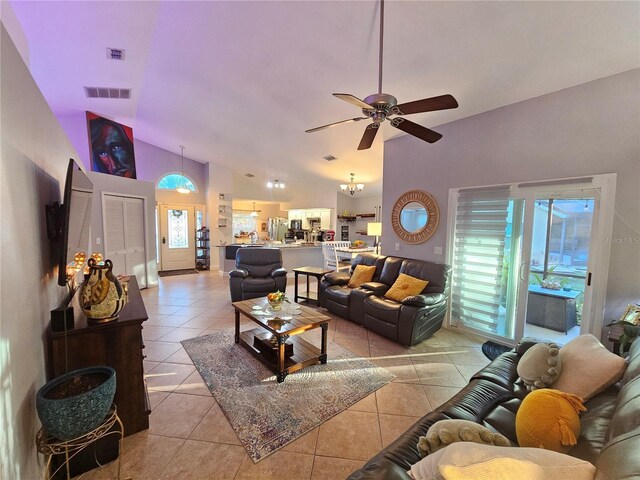 living room featuring light tile patterned floors, ceiling fan with notable chandelier, and high vaulted ceiling