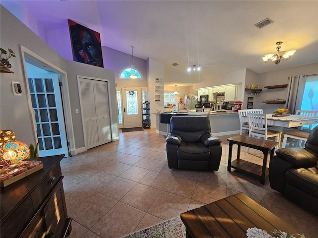 tiled living room featuring vaulted ceiling and an inviting chandelier