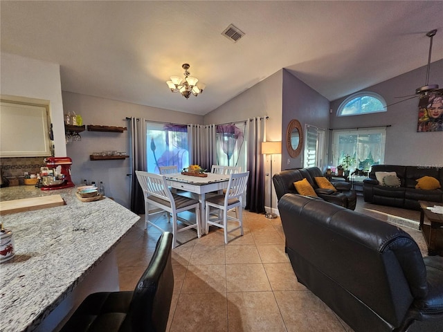 dining space featuring light tile patterned floors, vaulted ceiling, and a notable chandelier