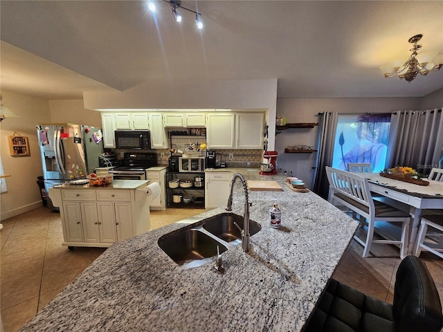 kitchen with backsplash, an inviting chandelier, sink, light stone countertops, and stainless steel appliances