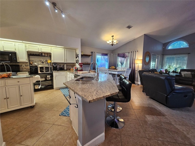 kitchen featuring a chandelier, a healthy amount of sunlight, sink, and vaulted ceiling