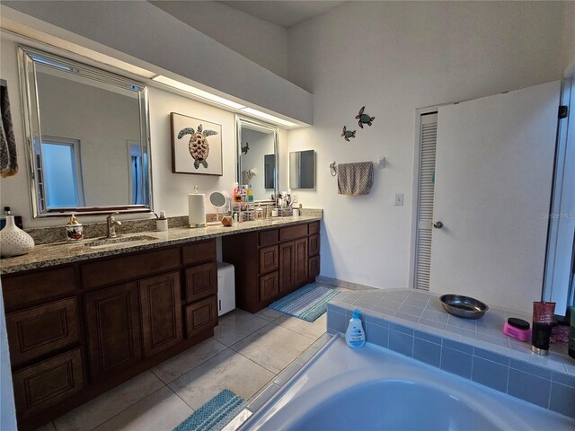 bathroom featuring tile patterned floors, a tub, and vanity