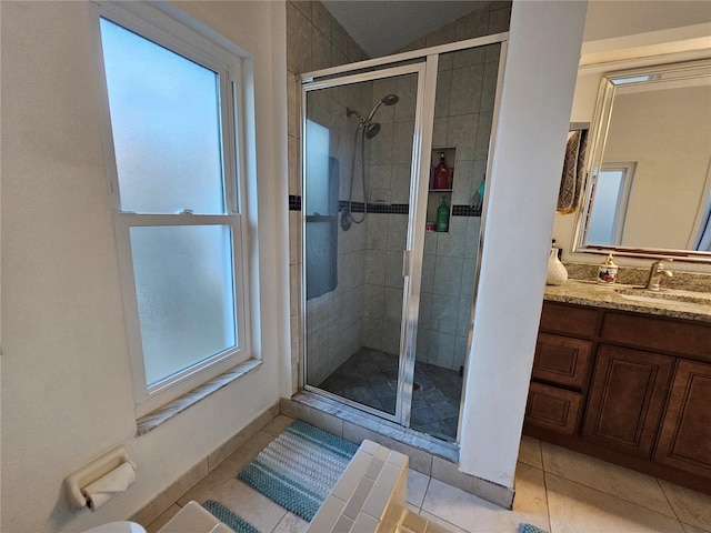 bathroom featuring tile patterned flooring, vanity, and a shower with door