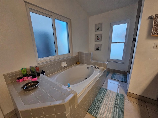 bathroom with tile patterned flooring and tiled bath