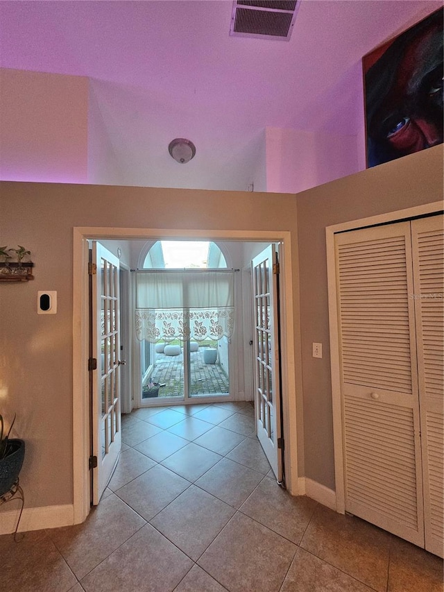 hallway featuring french doors and light tile patterned floors