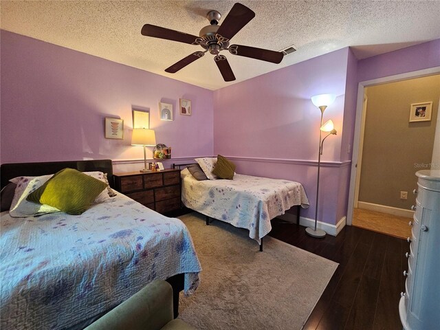 bedroom featuring a textured ceiling, ceiling fan, and dark wood-type flooring