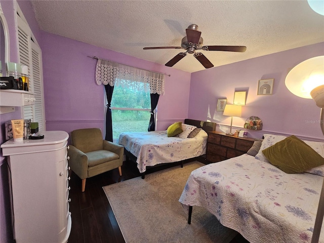 bedroom featuring ceiling fan, dark wood-type flooring, and a textured ceiling