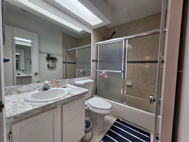 full bathroom with tile patterned floors, vanity, enclosed tub / shower combo, and toilet