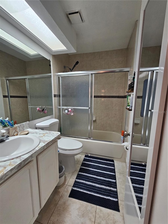 full bathroom featuring tile patterned flooring, vanity, enclosed tub / shower combo, and toilet