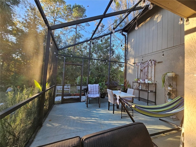 view of patio featuring glass enclosure