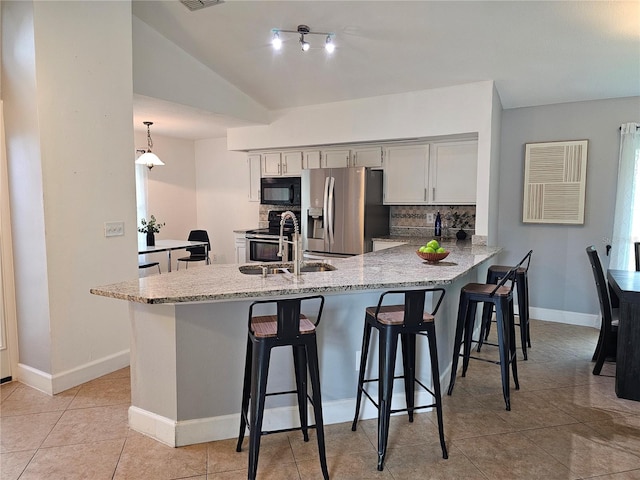 1022 Bartlett Ct, Oviedo, FL 32765 - kitchen with stainless steel appliances, a peninsula, tasteful backsplash, a breakfast bar area, and light stone countertops